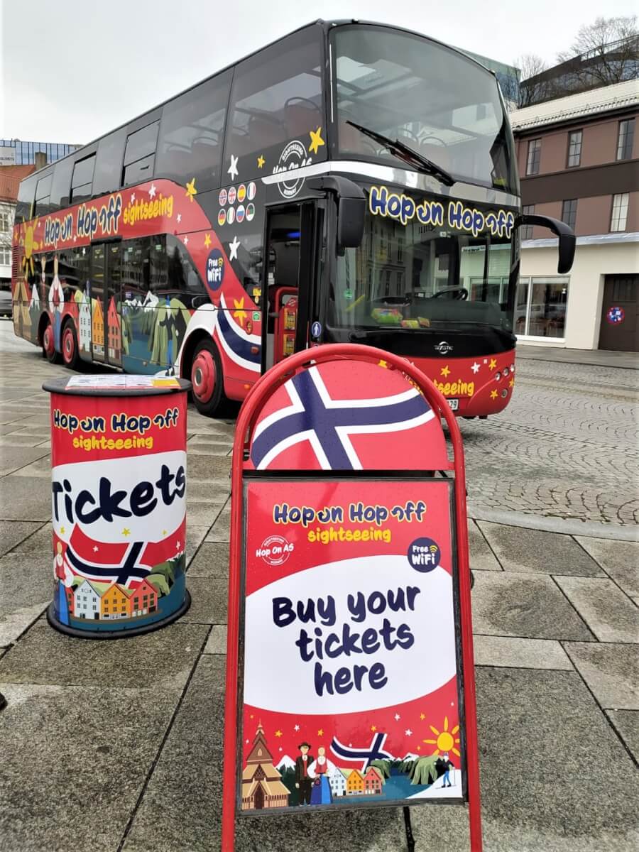 Hop on bus parked in Stavanger, with the booth to buy tickets showcased infront of it.